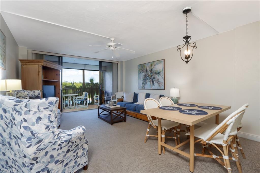 Living area featuring light carpet, ceiling fan, and baseboards