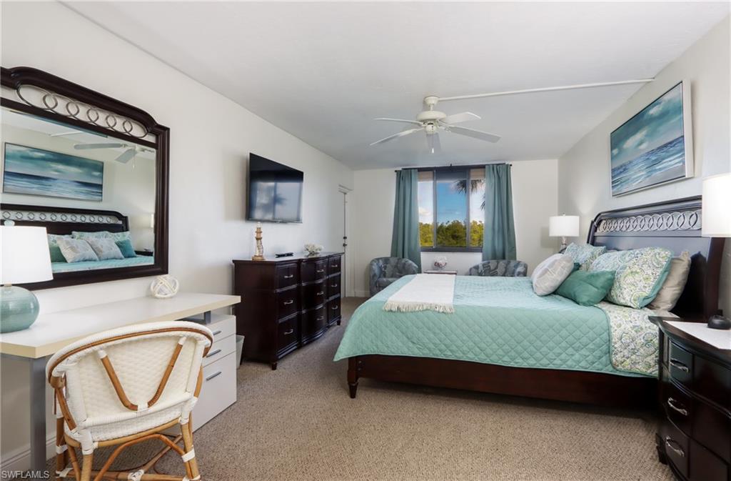 Carpeted bedroom featuring ceiling fan