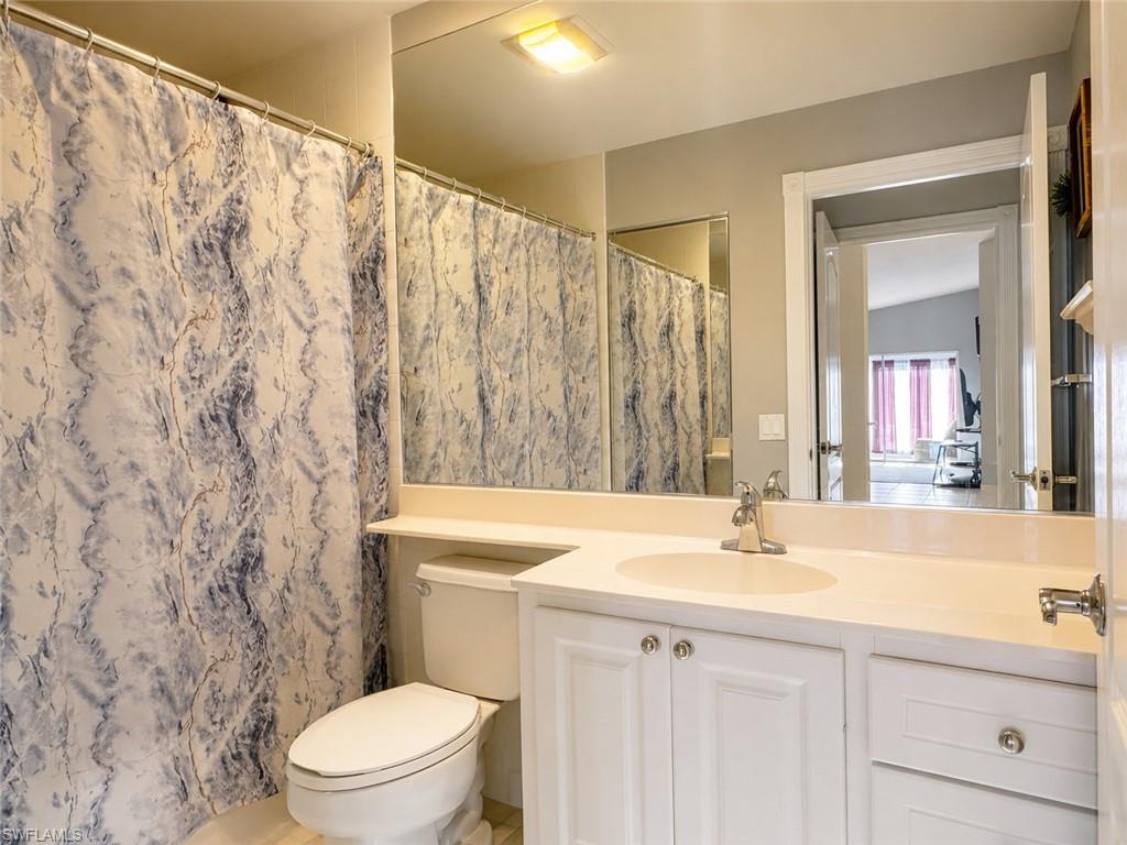 Vanity with integrated sink, white cabinetry, and polished chrome hardware