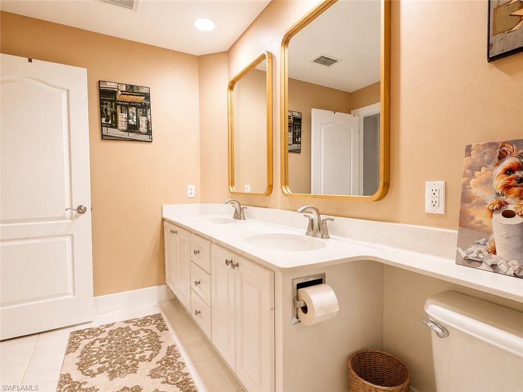 Double vanity with white cabinetry, dual undermount sinks, and a light-toned countertop