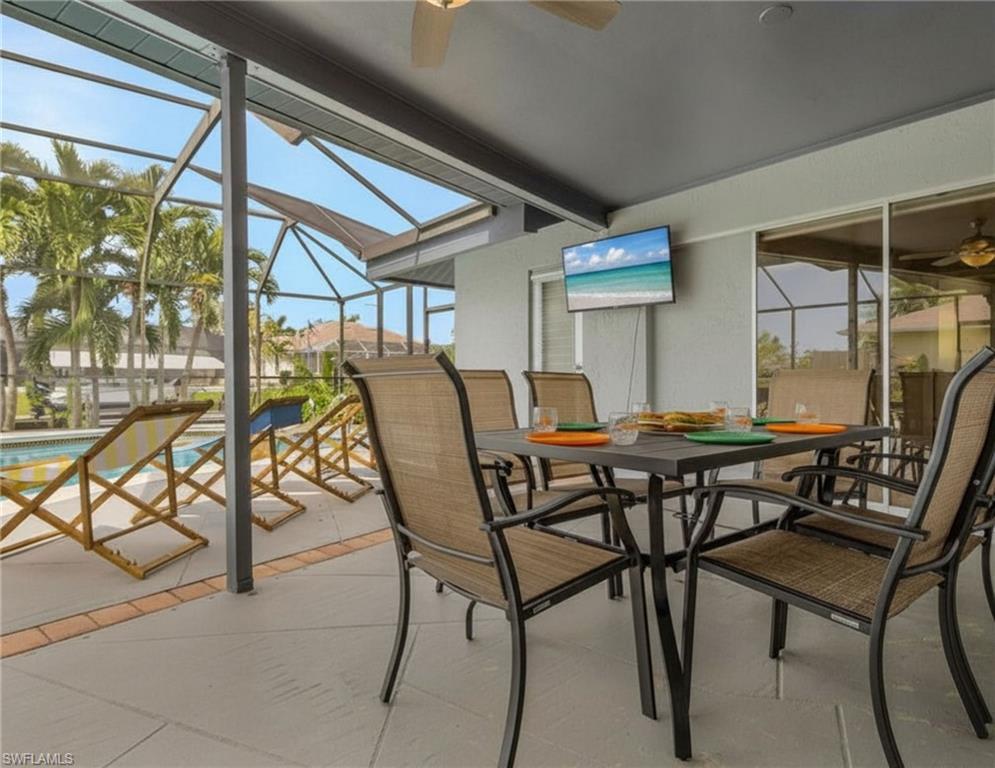 Screened-in pool deck featuring a free-form pool, stainless steel pool handrails, and a surrounding concrete patio