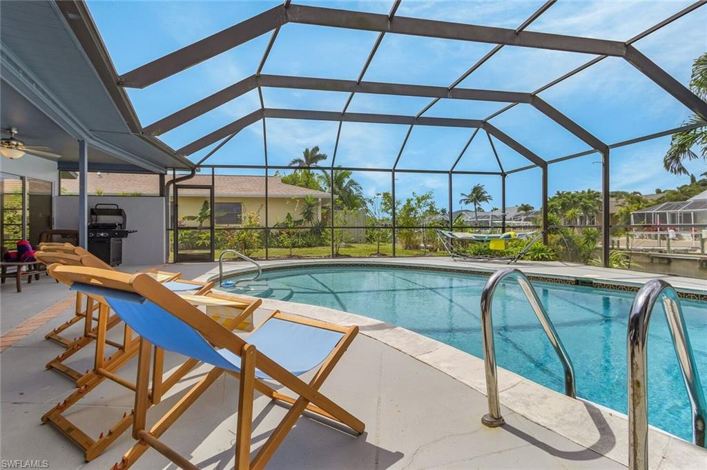 Screened outdoor swimming pool with a concrete pool deck and integrated steps