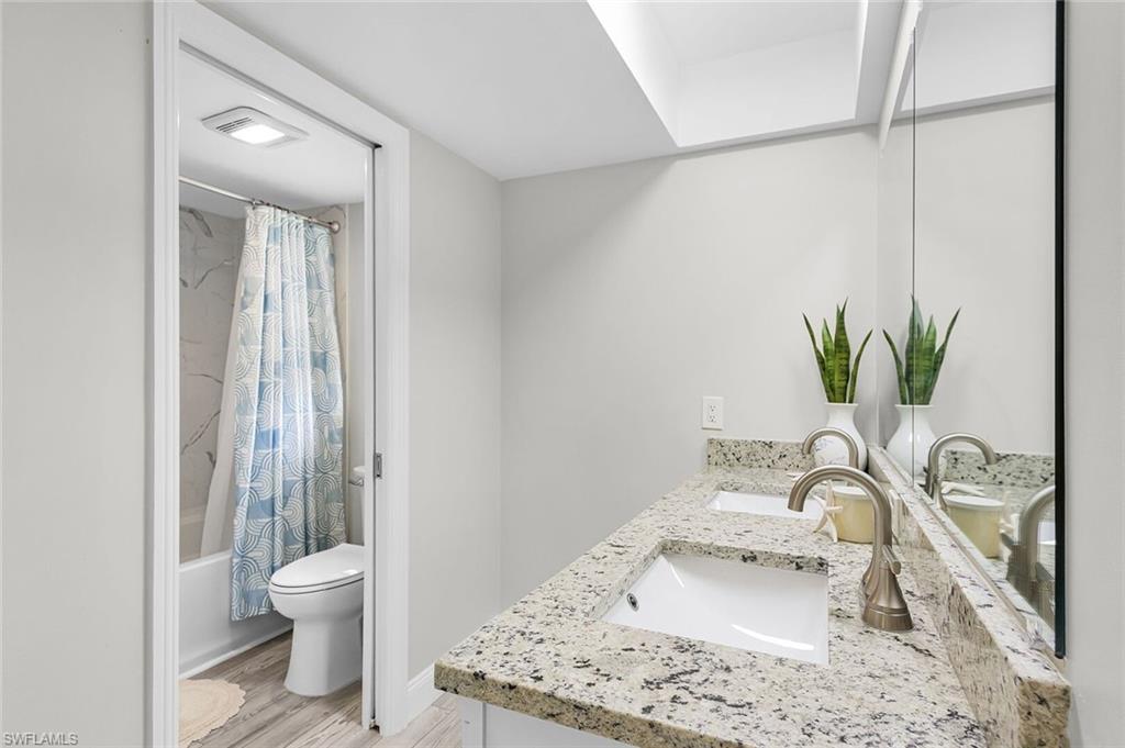 Wood-finish flooring, recessed lighting, window with blinds, and mirrored closet doors