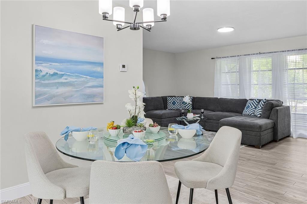 Dining area with wood-finish flooring and a contemporary chandelier