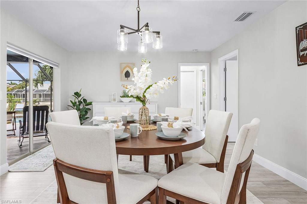 Kitchen featuring white cabinetry, light-colored countertops, stainless steel appliances, and wood-finish flooring