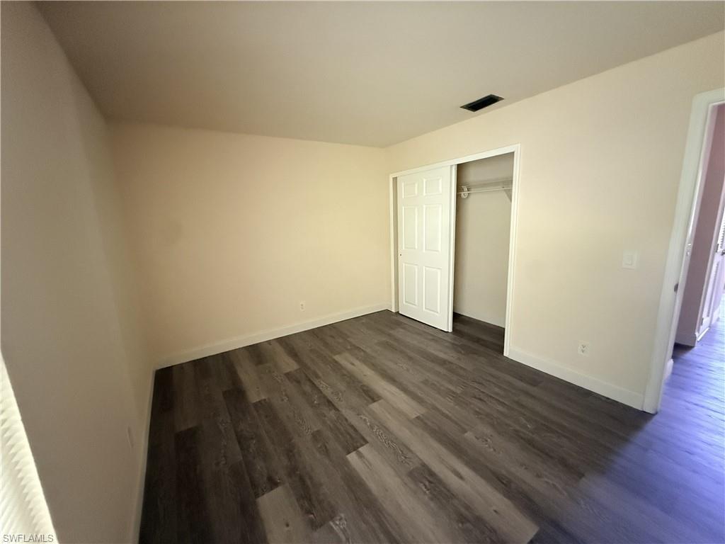 Wood-finish flooring, neutral wall tones, and a sliding closet door with interior shelving