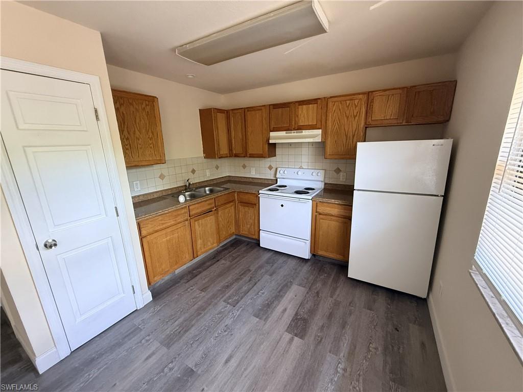 Kitchen with wood-finish cabinetry, laminate countertops, and a tile backsplash