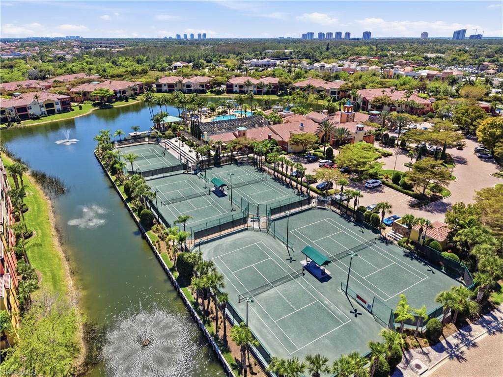 Expansive tennis courts with multiple playing surfaces, surrounded by mature palm trees and landscaping