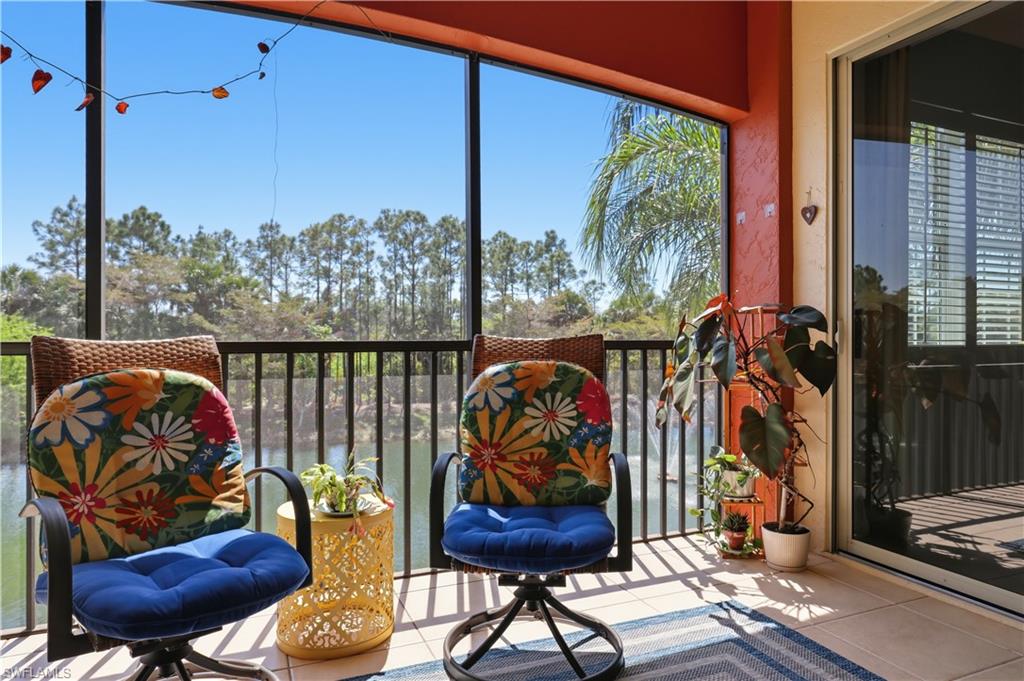 Screened balcony with tiled flooring, black metal railings, and a sliding glass door