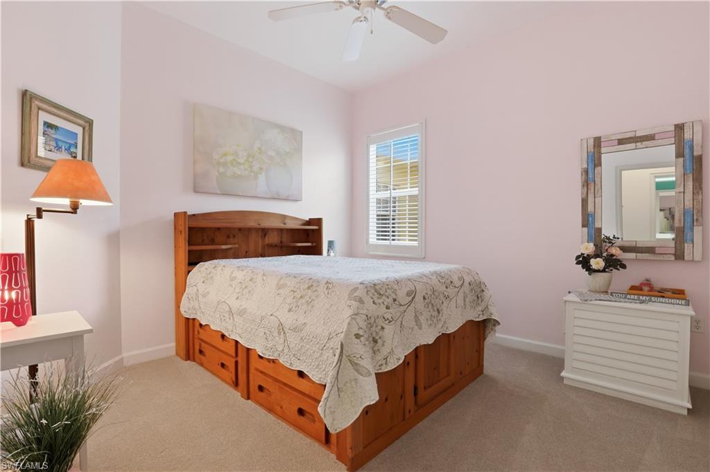 Carpeted flooring, window with blinds, wood-finish bed frame with built-in storage, and ceiling fan