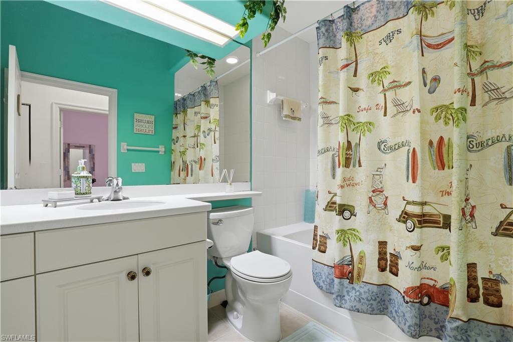 White vanity with storage cabinetry, integrated countertop, and an undermount sink