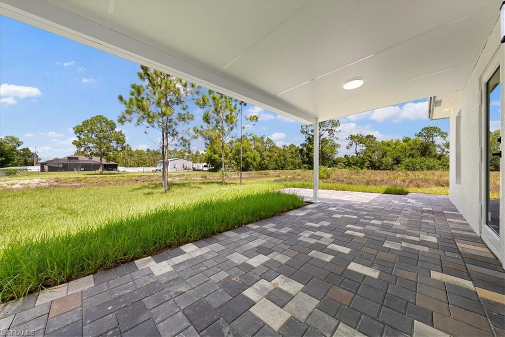 Covered patio with patterned paver flooring and an outdoor light fixture