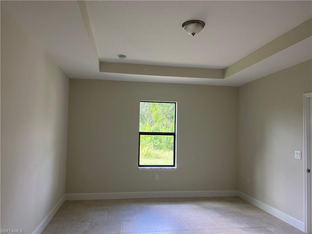 Tray ceiling with recessed lighting element, single-pane window, flush-mount ceiling light fixture, and tiled flooring