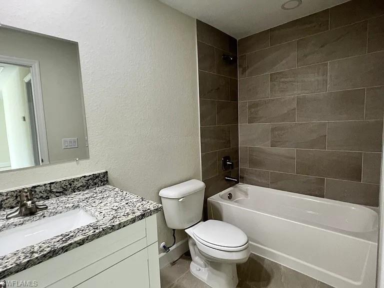 White vanity with a speckled countertop, undermount sink, and brushed nickel faucet
