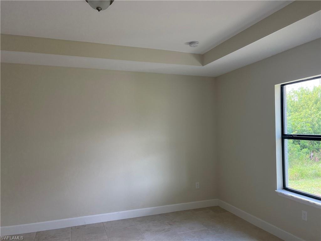 Tray ceiling, recessed lighting, neutral wall tones, tile flooring, and a black-framed window
