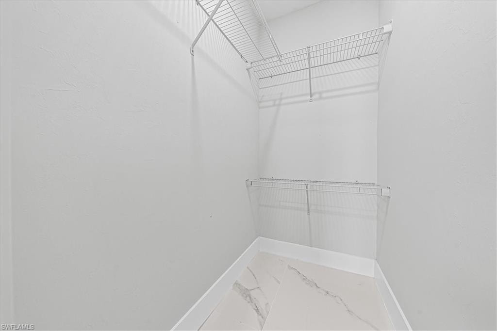 White wire shelving, white walls, and light-toned tile flooring
