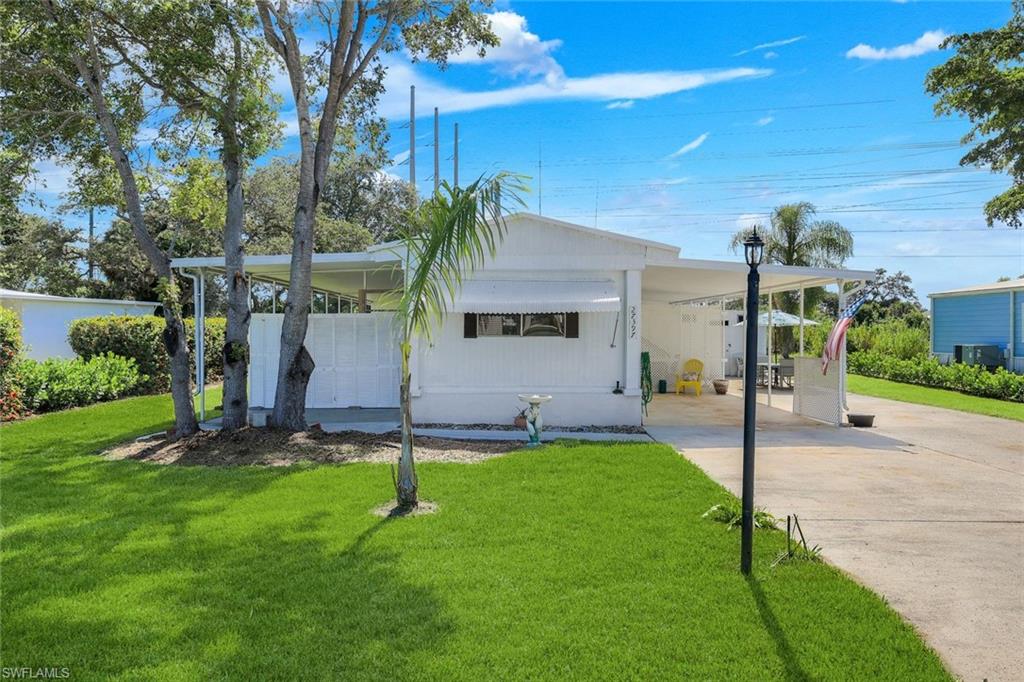 White single-story dwelling with an extended covered carport and a paved driveway