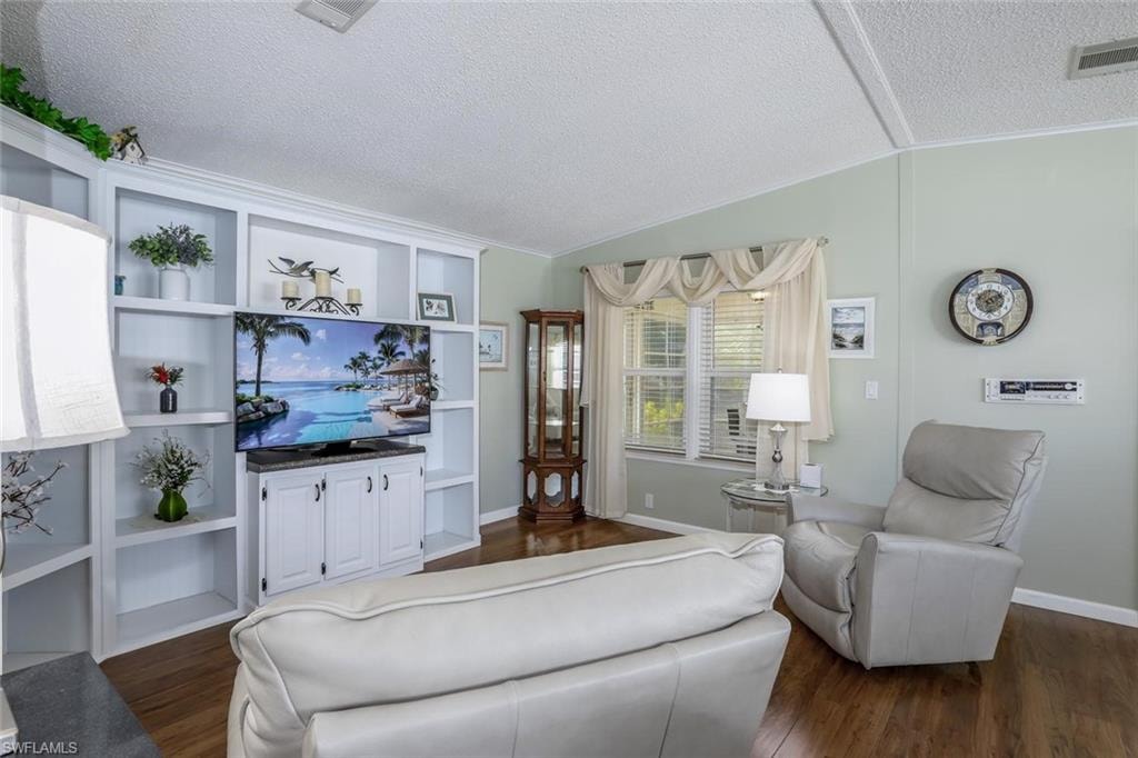 Built-in shelving with integrated media console, wood-look flooring, and natural light
