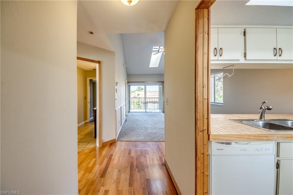 Corridor with sink, light carpet, and a skylight