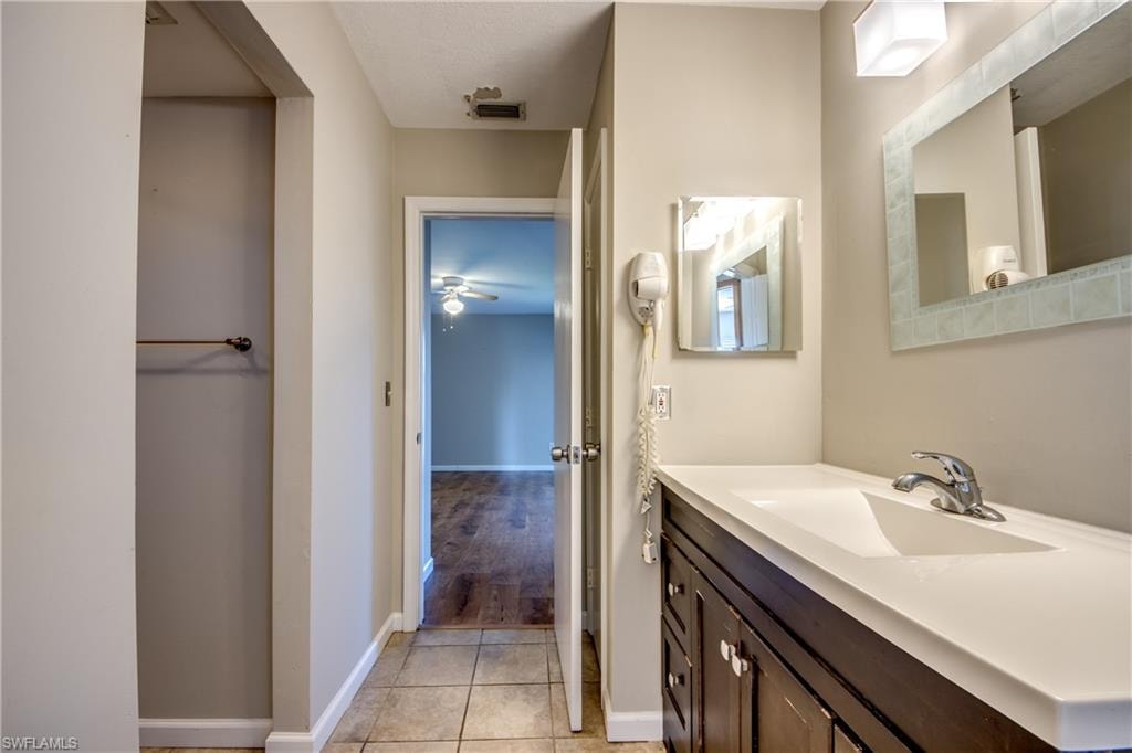 Bathroom with vanity, tile patterned flooring, and ceiling fan