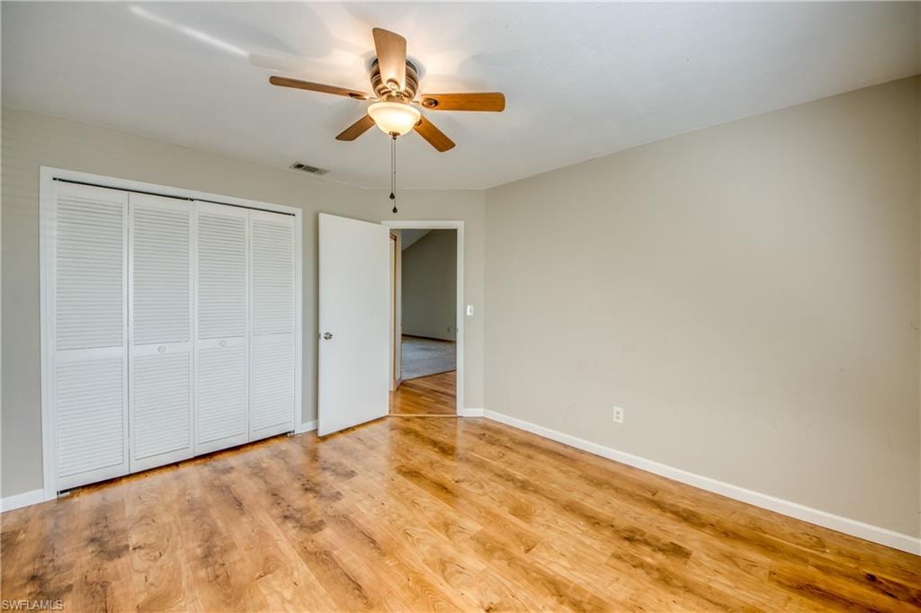 Unfurnished bedroom with light hardwood / wood-style floors, a closet, and ceiling fan