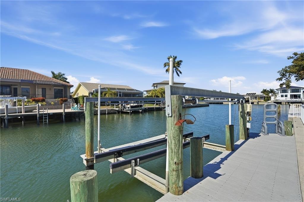 Waterfront property featuring a private boat lift, a composite dock, and direct canal access