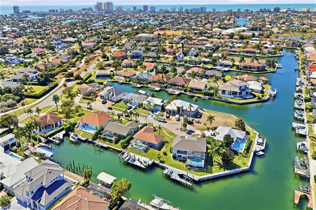 Waterfront property featuring a private boat dock, residential canals, and established landscaping