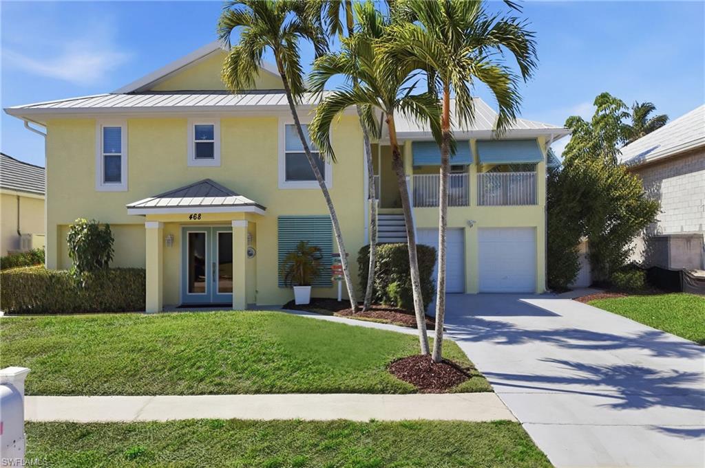 Coastal-inspired exterior with light yellow stucco siding and a metal roof