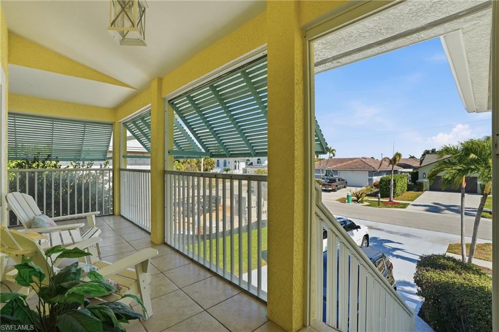 Covered porch with tiled flooring and white railings