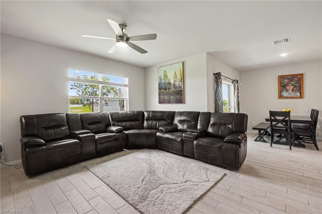 Recessed lighting and a ceiling fan illuminate the expansive living area