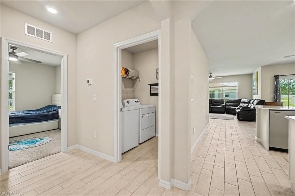 Tile flooring, laundry area for appliances, ceiling fan, recessed lighting, and white trim throughout