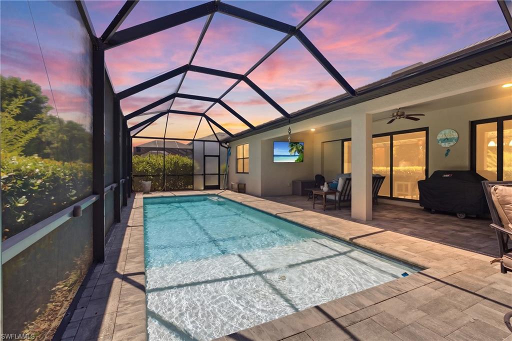 Screened-in outdoor pool with surrounding paver decking