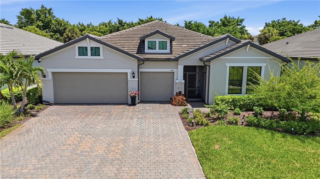 Dockside Floor Plan with Stucco exterior, tiled roof, paver driveway, three-car garage, and beautiful landscaped front yard.