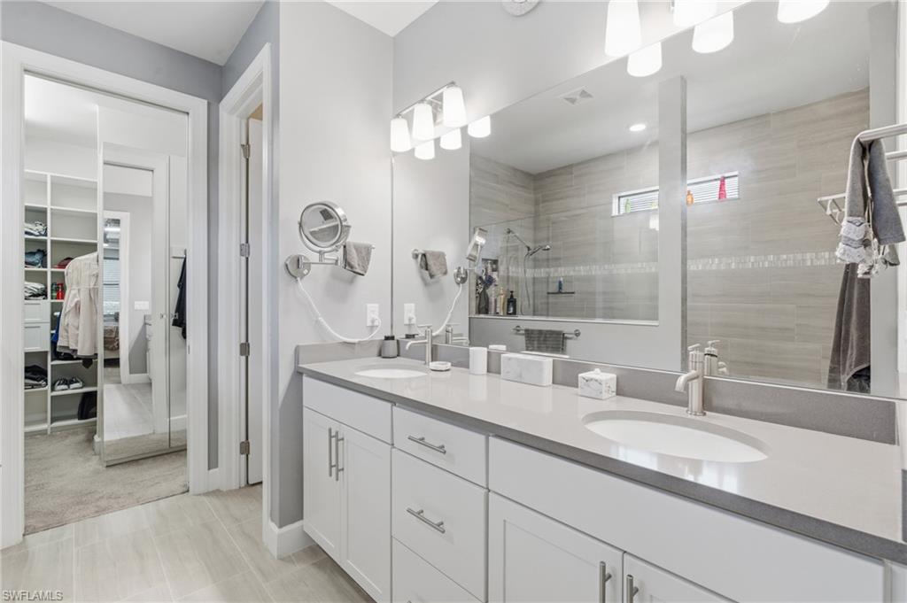 Dual vanity with undermount sinks, light-toned countertop, and white cabinetry