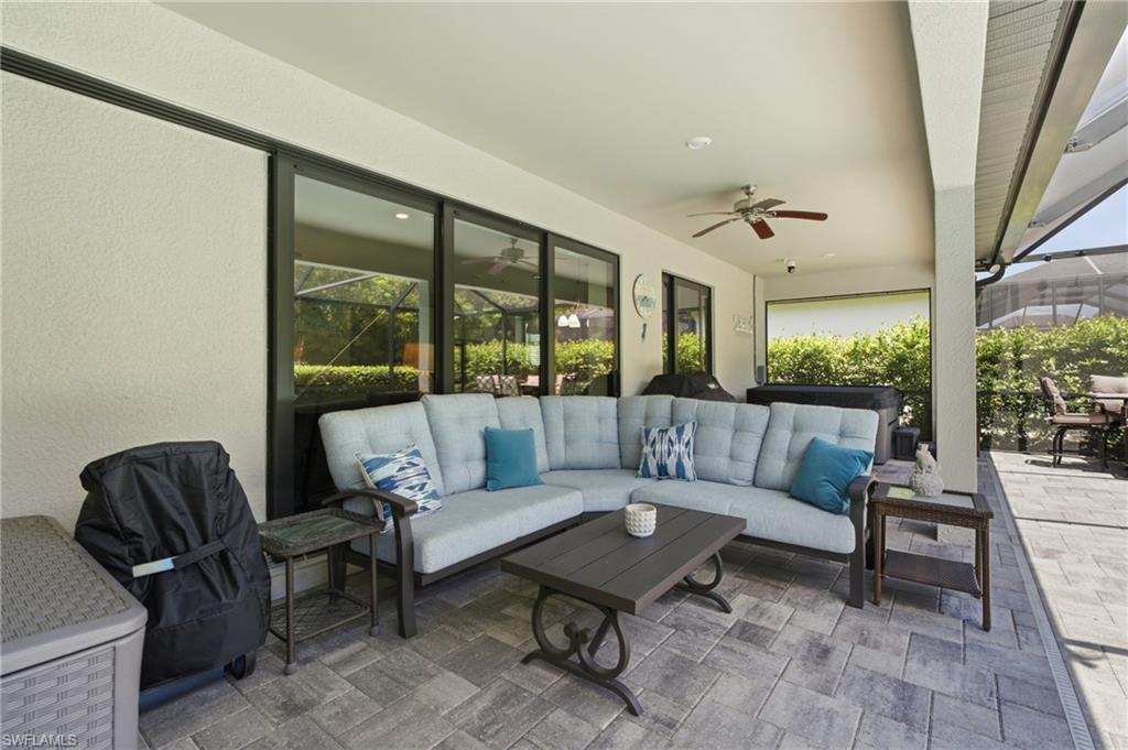 Expansive covered patio featuring paver flooring, a ceiling fan, and large sliding glass doors