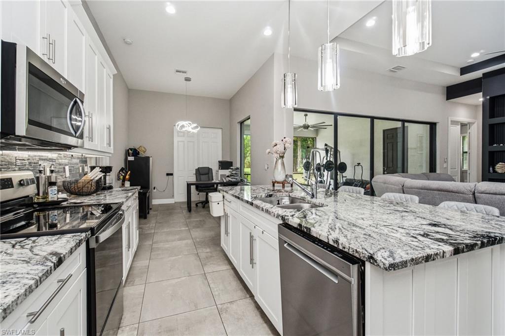 Kitchen featuring white cabinetry, stainless steel appliances, and stone countertops