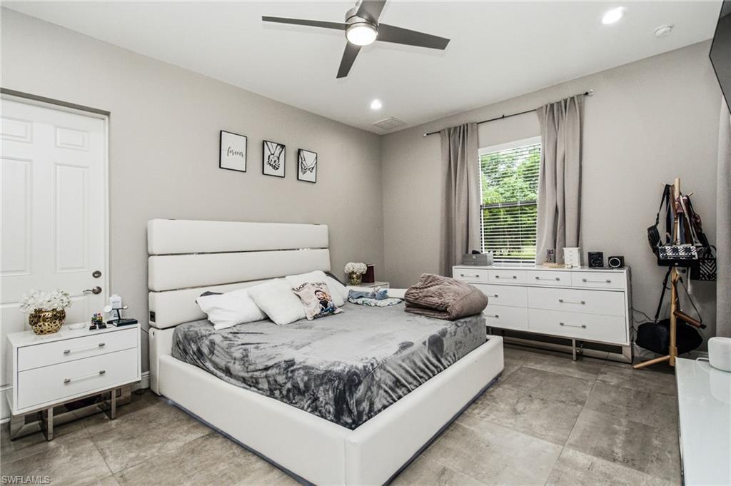 Recessed lighting illuminates the space, featuring a ceiling fan, a window with blinds, and tile flooring