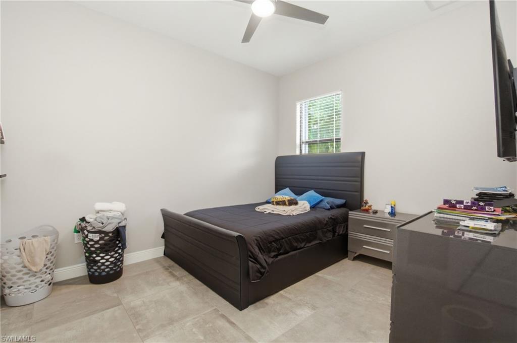 Recessed ceiling fan, window with blinds, light-colored walls, and large format floor tiling