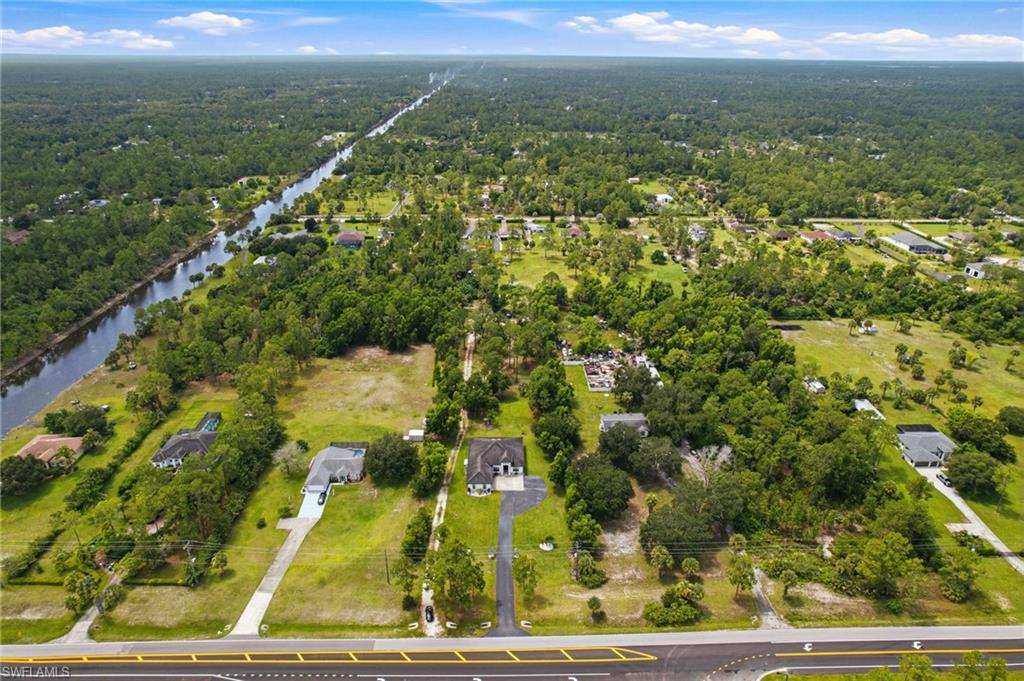 Expansive property featuring a canal, paved road frontage, and numerous mature trees