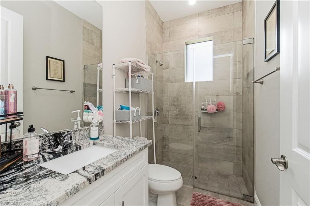 Vanity with a polished granite countertop, rectangular undermount sink, and chrome faucet