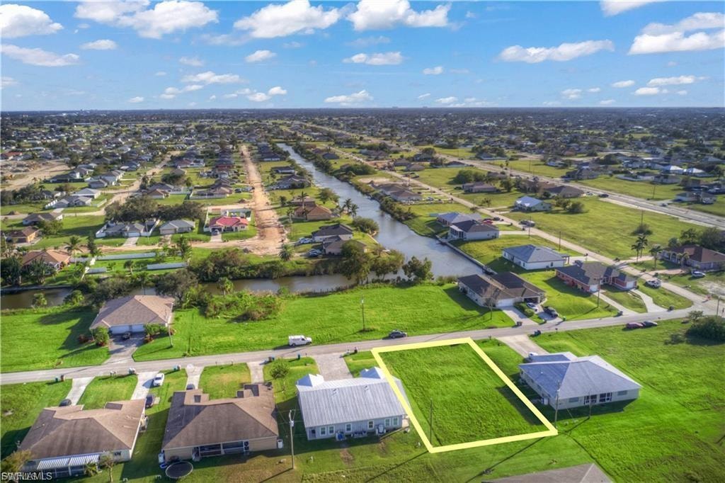 Aerial perspective of suburban area featuring property boundaries highlighted and a large body of water
