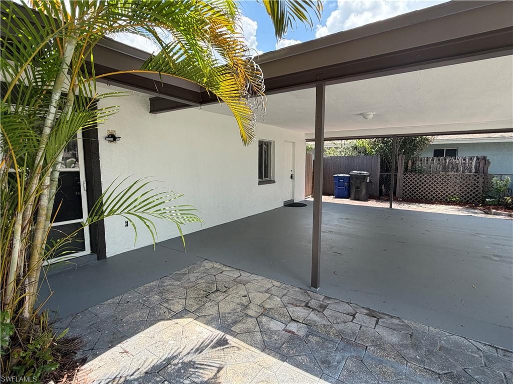Covered carport with ample parking, direct entry access, and exterior lighting