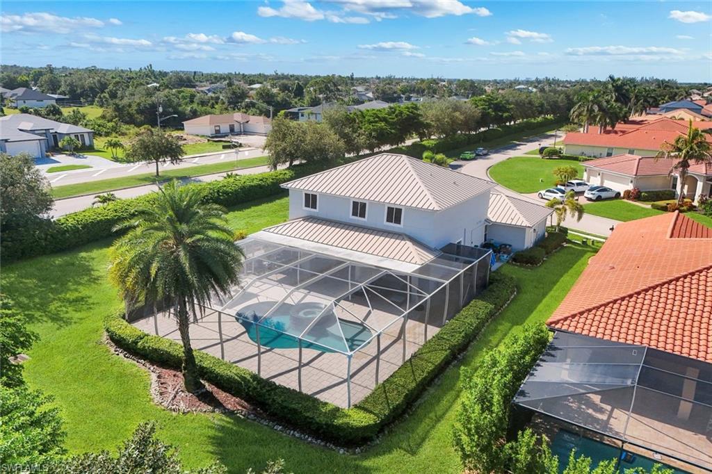 Contemporary home with a screened swimming pool, paver patio, and mature landscaping