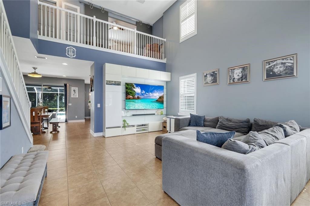 Two-story living area featuring a prominent loft, recessed lighting, and tile flooring