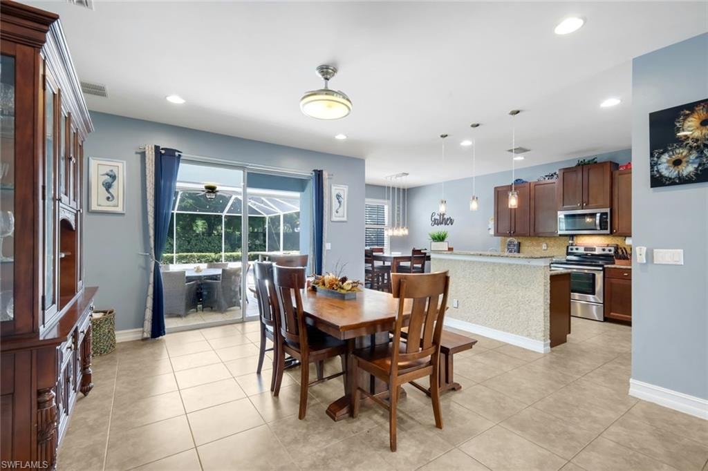 Spacious kitchen and dining area featuring tile flooring, stainless steel appliances, and a screened patio