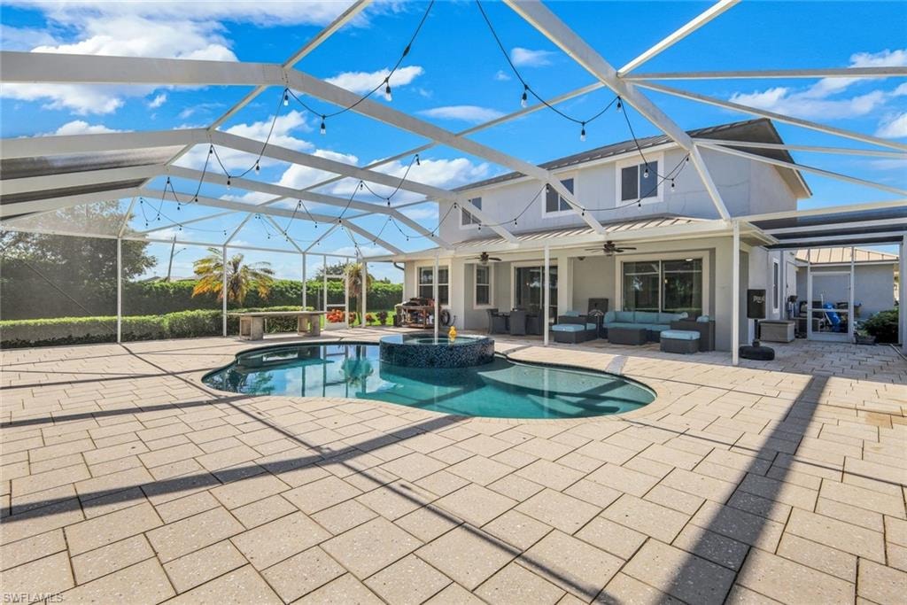 Screened-in outdoor living space with a paver patio, integrated pool, and a covered lounge area