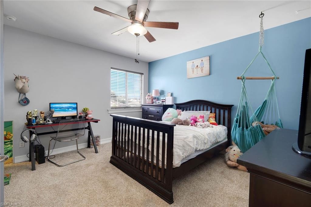 Wall-to-wall carpeting, window with blinds, ceiling fan with integrated lighting, and painted walls