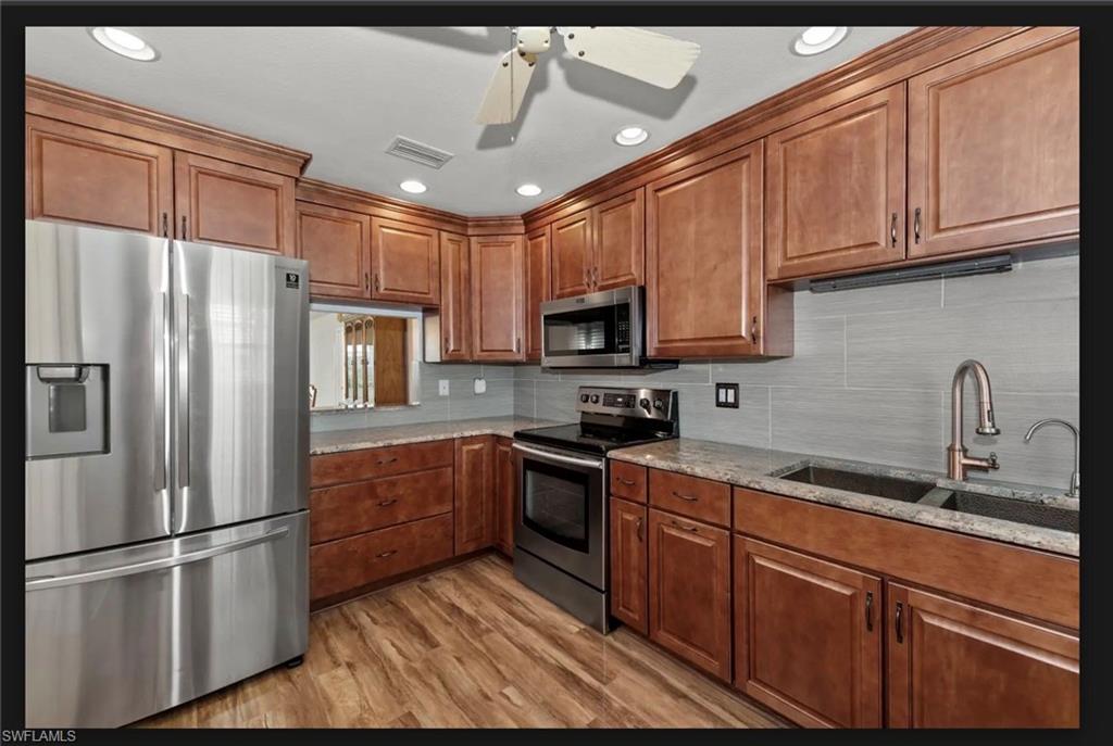 Elegant wood color high end cabinetry, gorgeous backsplash new facuset, cooper color sink, fridge with freezer