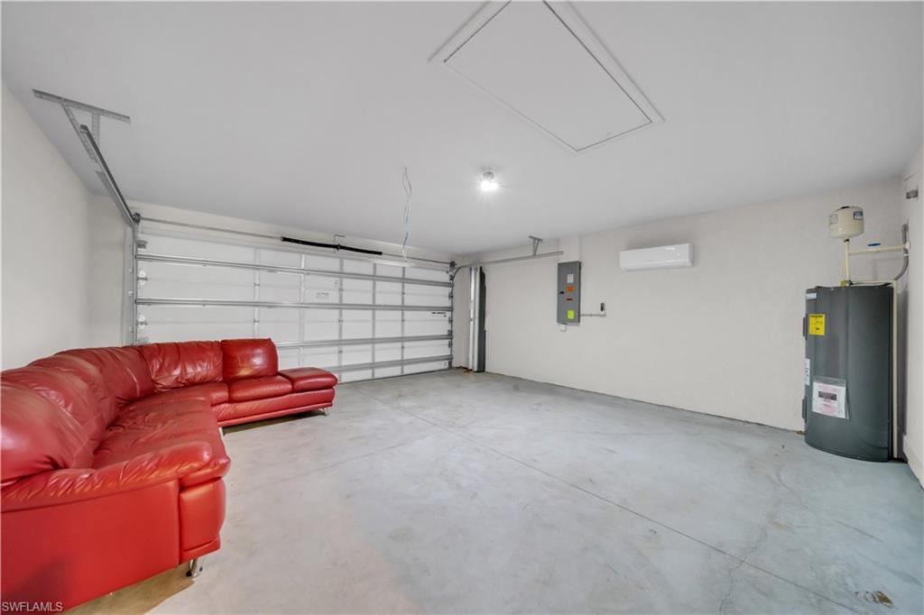 Attached garage with white sectional garage door, concrete flooring, and ceiling-mounted light fixture