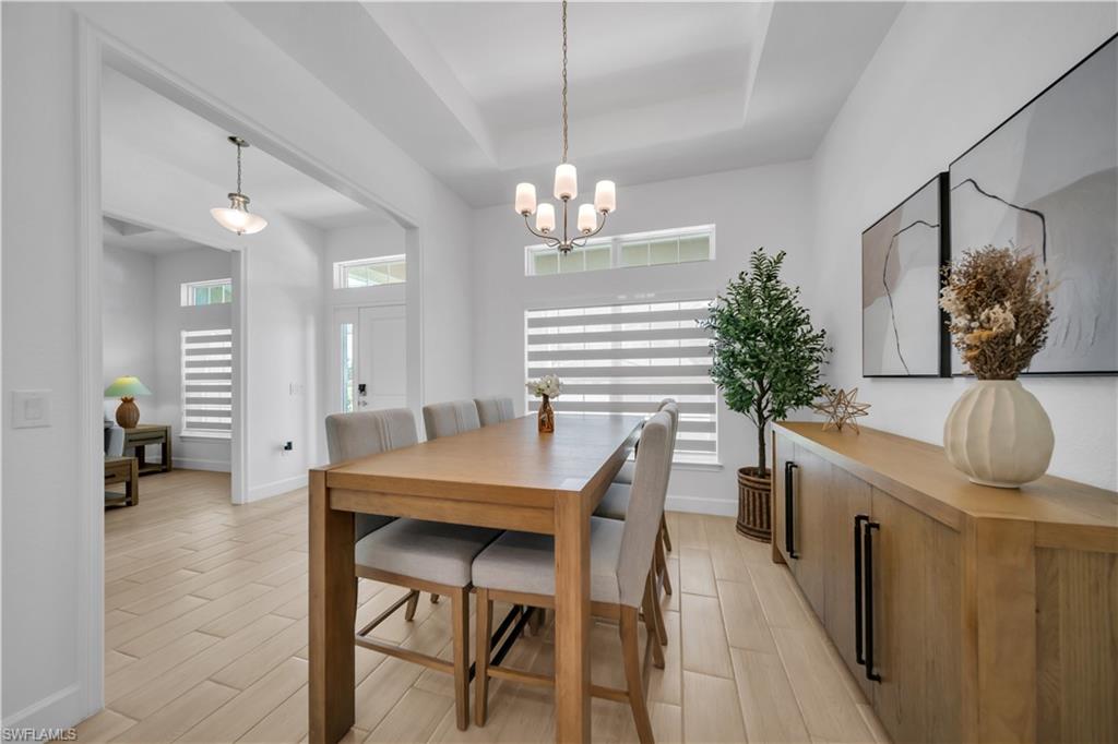 Recessed ceiling detail, wood-finish flooring, multiple windows with horizontal blinds, and a built-in wood-tone credenza with dark hardware